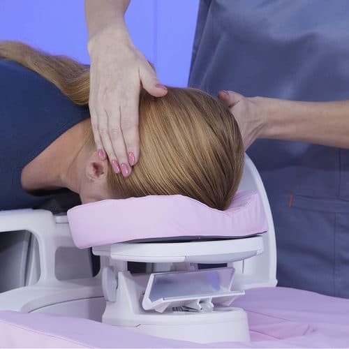 Patient being positioned with padded head support during MR imaging.