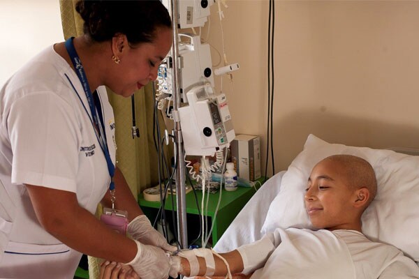 Child with cancer receives treatment from a nurse